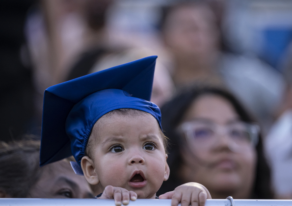 6-month-old Leanna Robles wore her very own mortarboard  to watch commencement for East View High School at the Georgetown ISD Athletic Complex on Friday, May 23, 2025.  489 East View seniors received their diplomas.    Photo by Andy Sharp.