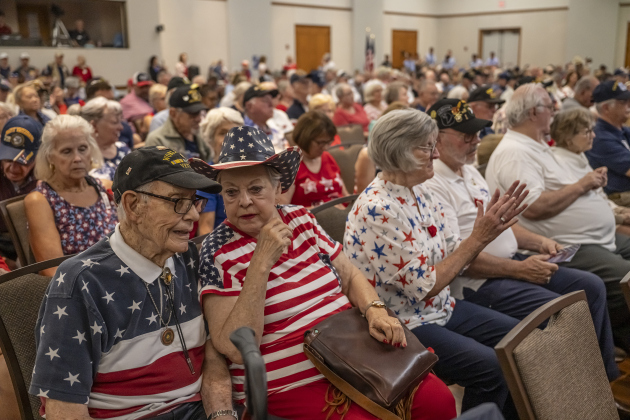 World War II veteran (Navy) John Dunn, left, who will be 97 in August, is shown with his wife Linnea while attending the Memorial Day ceremony in Sun City on Monday, May 26, 2025.  Approximately 600 were in attendance.  Rain chances moved the event indoors.   Photo by Andy Sharp.  