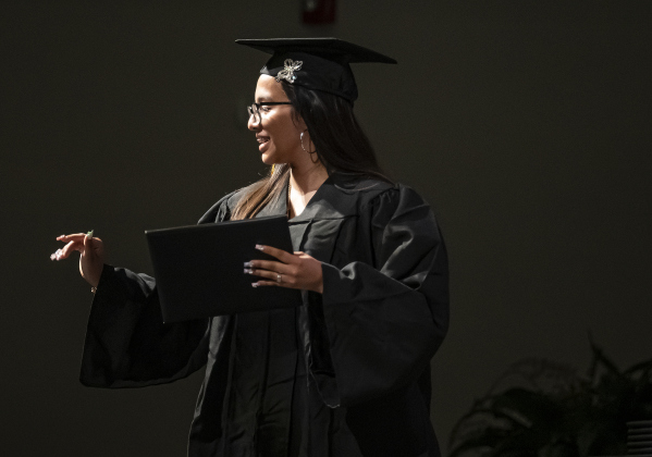 Erika Aracely Moreno waves to audience members after receiving her diploma.