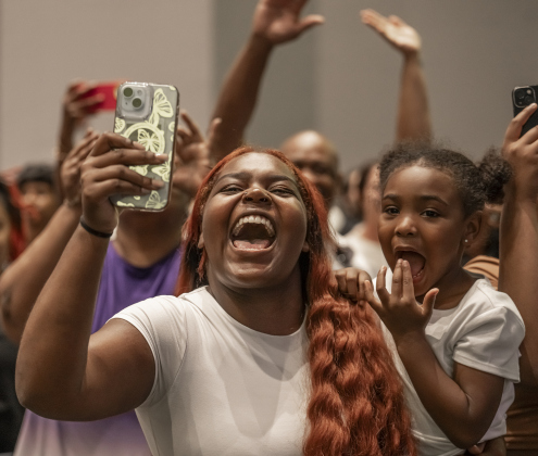 Akeelah Smith, 16, with her sister, Kenzie Vance, 4, cheers on her cousin, graduating senior Keyaira Griffin  during the Richarte High School commencement ceremony.
