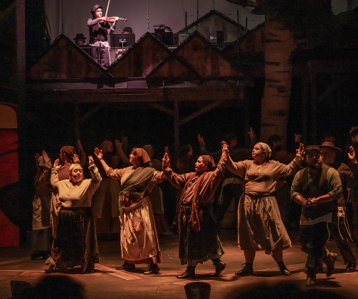 Hayden Smith, top, as Fiddler on the Roof, joins other cast members  in a photo from the dress rehearsal for the Palace production of “Fiddler on the Roof”  on Thursday, May 29, 2025.  The play will run through July 6th on the Springer main stage.    Photo by Andy Sharp.
