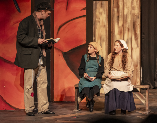 Matthew Hubble, left, playing Perchik, Lovelyn Cessac, center, as Bielke, and Eden Cessac, right, as Shprintze, are shown in a photo from the dress rehearsal for the Palace production of “Fiddler on the Roof”  on Thursday, May 29, 2025.  The play will run through July 6th on the Springer main stage.    Photo by Andy Sharp.