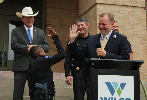 DJ high-fives County Judge Steven Snell after laughing at a joke.