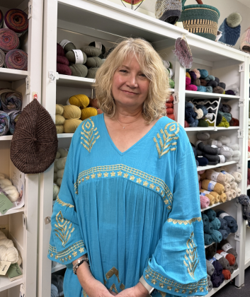 Shawnee Kunz, owner of The Knitting Cup, standing in front of her yarn inventory. The store sells pat- terns by Ms. Kunz’s longtime customer and friend, Martha Wissing.