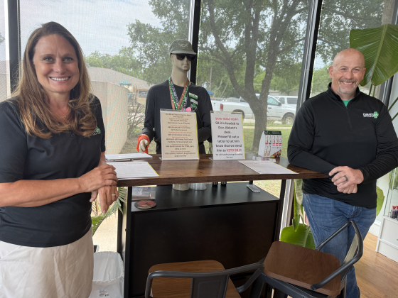 Kate Cerasoli (left), owner of Pinnacle Essentials, standing with Steve Marengo (right), the Director of Operations at Pinnacle Essen- tials. Between them is a table in the store designated for writing letters to Governor Abbott. Photo by Abbey Archer