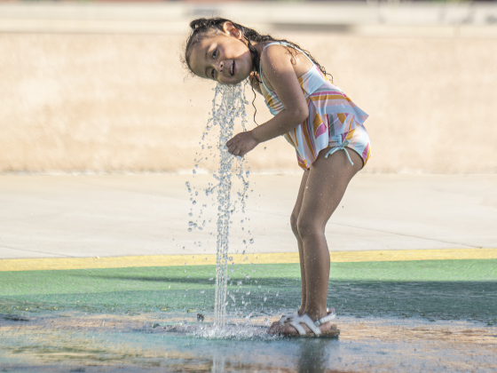 Anahi listens to the water spout as she plays in the Heritage Square Park splash pad.