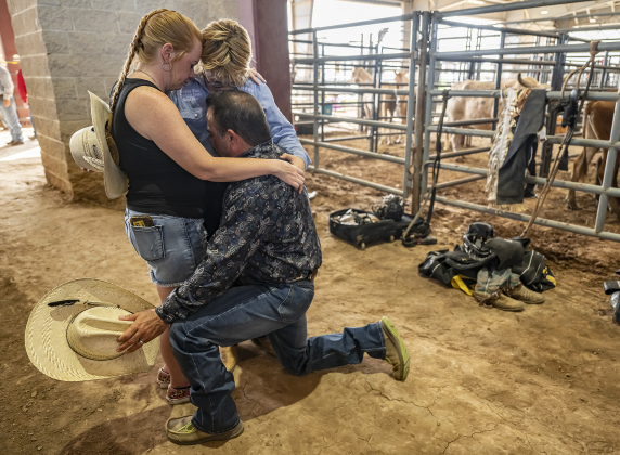 12-year-old Shilow Wilson, a saddle bronc rider from Coldspring, Texas, is joined by his parents, Amber and Jeff Wilson in a prayer for his safety during  the Bill Pickett Youth Rodeo, held at the Williamson County Expo Center  on Saturday, June 21, 2025.  Now in its second year, the rodeo showcases athletes 18 or younger. The event is coordinated by the Bill Pickett Youth Rodeo Association.     Photo by Andy Sharp.