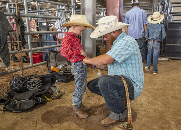 5-year-old Colt Fletcher of Leggett, Texas, who participated in Mutton Bustin’ and calf riding, is assisted by his father Tanner Fletcher as he prepares to compete  during the Bill Pickett Youth Rodeo, held at the Williamson County Expo Center  on Saturday, June 21, 2025.  Now in its second year, the rodeo showcases athletes 18 or younger. The event is coordinated by the Bill Pickett Youth Rodeo Association.     Photo by Andy Sharp.