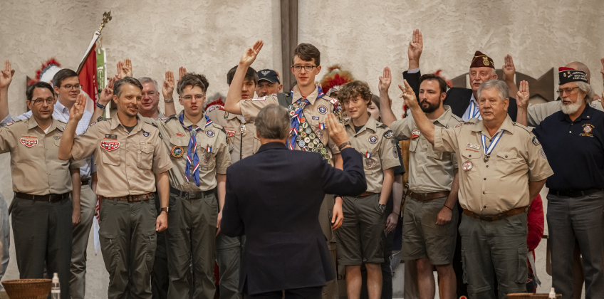 Former Texas Governor Rick Perry (back to camera) leads a group of Eagle Scouts and former Eagle Scouts in the Scout Pledge.