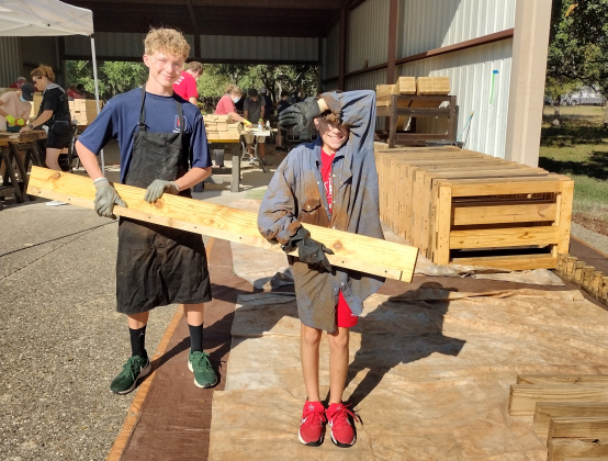 Cole Benson, 14, and Astin Carrillo, 12, carry a board that will soon be part of a bed for a boy or girl in the Georgetown area. Both young men volunteered their time for Sleep in Heavenly Peace. Cole attends Meridian World School in Round Rock and Astin is home schooled.