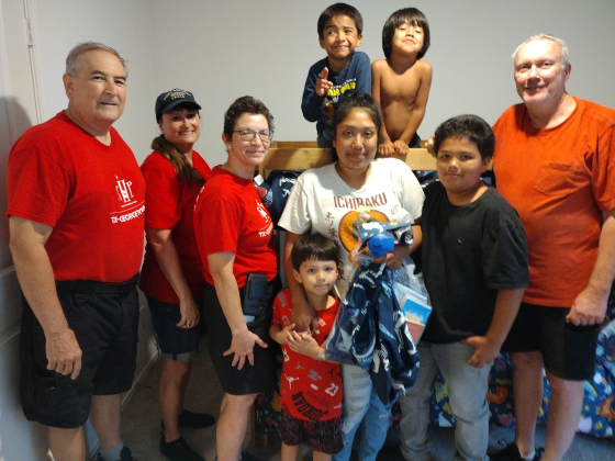 Jarrell homeowner Rebecca Pola, center, and family members pose in front of their new bed with Sleep in Heavenly Peace volunteers Ed Petrere, Myra Page, Evelyn Petrere and John Eldridge.