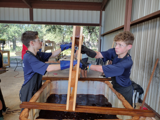 Haddon Hanzeoka and Jake Benson apply stain to sanded pine, as part of the Sleep in Heavenly Peace assembly line process September 21. Both are 14-year-old freshmen at Meridian World School in Round Rock.