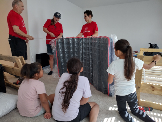 Kids watch in fascination as a mattress is inflated.