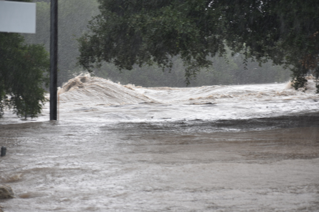 The San Gabriel River roars through Blue Hole Park. Water covers Rock Street up to Second Street in Georgetown.