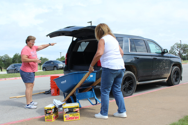 Liberty Hill volunteers load a wheelbarrow, buckets and heavy-duty trash bags to deliver to a victim who will be removing debris. The supplies were donated by Home Depot. Photo by Nalani Nuylan.