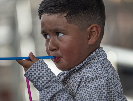 7-year-old Jackson Long enjoys a foot-long corn dog before taking part in Mutton Bustin’ at the  75th Annual Taylor Rodeo on Thursday, July 17,2025.  Coordinated by the Taylor Rodeo Association, the three-night rodeo is held at the Williamson County Expo Center.   Photo by Andy Sharp.