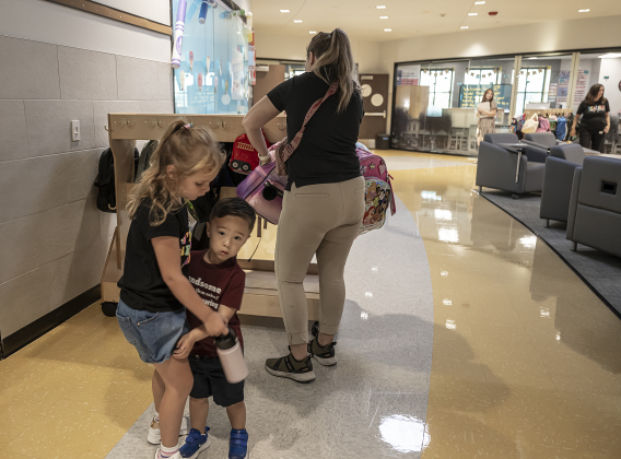 Second grader Olivia Gaines, left, celebrating her 7th birthday today, says goodbye to her little brother Ezra Watkins, 3, as she prepares to go into her classroom on the first day of school at Annie Purl Elementary School on Thursday, August 14, 2025.  Annie Purl has 650 students enrolled this academic year.    Photo by Andy Sharp.