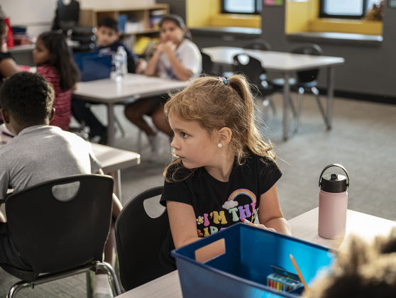 Olivia Gaines, who turns 7 today, settles into her second grade classroom, looking toward the door at her parents and little brother, 3-year-old Ezra Watkins on the first day of school at Annie Purl Elementary School on Thursday, August 14, 2025.  Annie Purl has 650 students enrolled this academic year.    Photo by Andy Sharp.