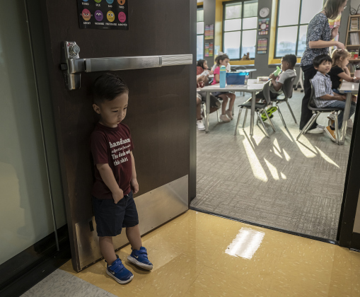 3-year-old Ezra Watkins, left, well-bonded with his second-grade  sister Olivia Gaines (7-years-old today) was feeling down about having to go home without her  on the first day of school at Annie Purl Elementary School on Thursday, August 14, 2025. Olivia is at far back right.   Annie Purl has 650 students enrolled this academic year.    Photo by Andy Sharp.