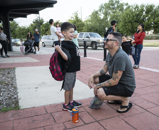 5-year-old Oliver Brown, left, a kindergartner, spends time with his father Derek Brown outside with other families before the doors open for classes  on the first day of school at Annie Purl Elementary School on Thursday, August 14, 2025.  Annie Purl has 650 students enrolled this academic year. Photo by Andy Sharp.