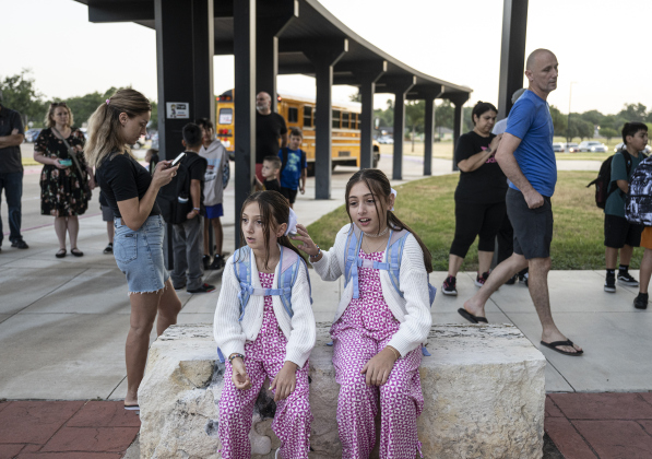 8-year-old Rina Metaliaj, left, a third grader, and her sister Adela, 10, a fifth grader, wore matching outfits as they waited for classes to begin  on the first day of school at Annie Purl Elementary School on Thursday, August 14, 2025.  Annie Purl has 650 students enrolled this academic year.    Photo by Andy Sharp.