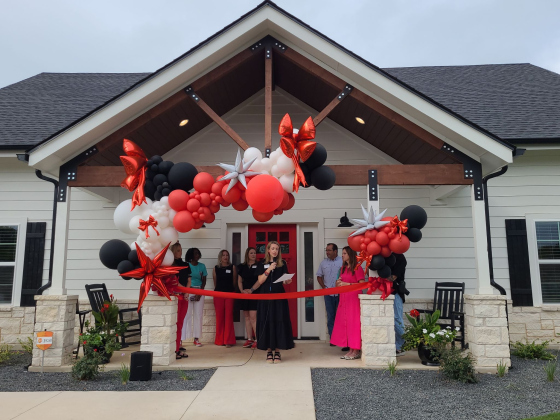  Isaiah 117 House Williamson County Location Leader Tara Thornton, center, gives a speech before cutting the ribbon to open the house, September 6. Photo by Nalani Nuylan.
