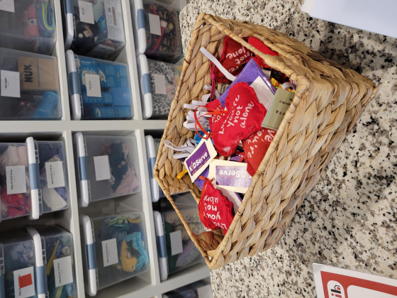 A basket filled with hearts with “Love, you’re not alone” sits on a counter in the donation room where kids can get new clothes and other personal items when they arrive to the house.  Photo by Nalani Nuylan.