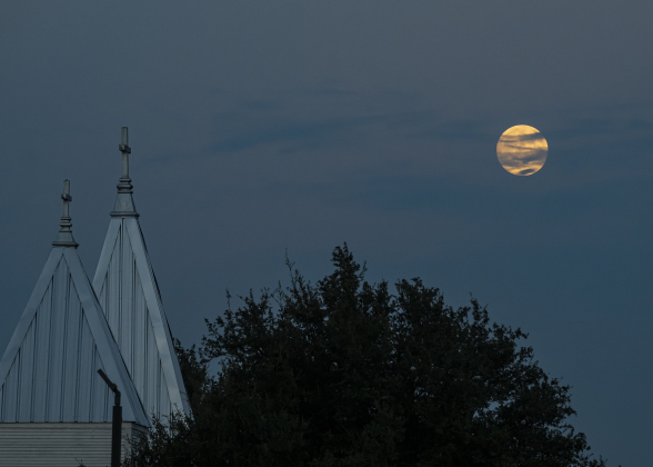 A Waxing Gibbous moon, nearly full at 99.2% visibility, shines over Zion Lutheran Church in Sandoval (along County Road 425) on Saturday, September 6, 2025.