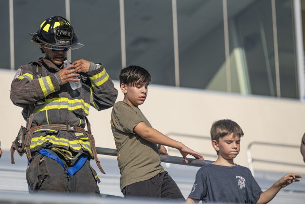 Georgetown Fire Department firefighter Jonathan Marquez, left is accompanied by his sons Jude, 12, and Micah, 8, during the Memorial Stair Climb.