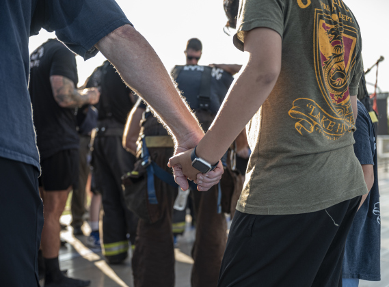 First responders and their families join in prayer at the conclusion of the Memorial Stair Climb held at Birkelbach Field  on Thursday, September 11, 2025.