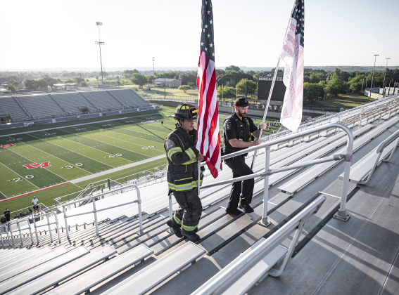 Georgetown Fire Department firefighter Dylan Otto carries the American flag while Georgetown Police Department Lt. Craig Ryan carries the Flag of Heroe on Thursday, September 11, 2025  as they post them at the top of the stadium steps during the Memorial Stair Climb held at Birklelbach Field, commemorating the 24th anniversary of the attacks on United States soil on September 11, 2001.