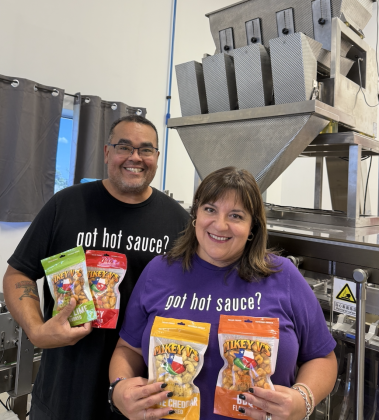 Michael Valencia stands with his wife, Tanya, in front of the Gator Toes bag sealer. The machine can seal 30 bags per minute. Photo by Abbey Archer