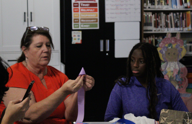 Jarrell Library Director Susan Gregurek, left, teaches Jarrell High School Senior Assia Bah, right, how to design a mum’s backing. Photo by Nalani Nuylan.