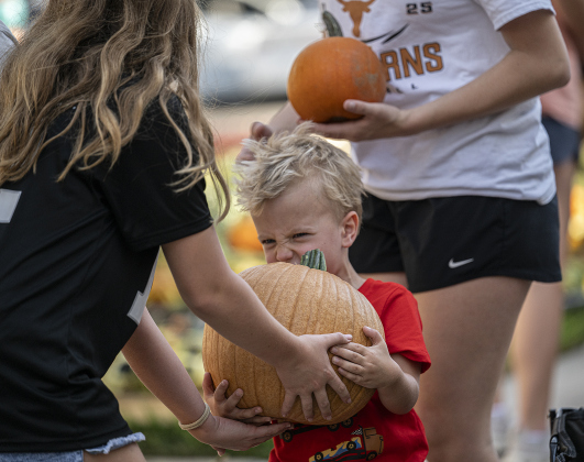 3-year-old Mo Paull gets some help with a pumpkin as he helps  unload more than 3,000 pumpkins at Georgetown First United Methodist Church on Wednesday afternoon, October 8, 2025.
