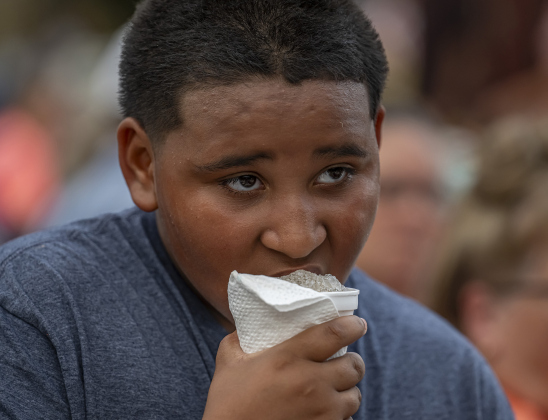 10-year-old Esparanza Garcia enjoys a snow cone during the National Night Out observance held at the Georgetown Housing Authority’s Stonehaven site  on Tuesday, October 7, 2025.  Photo by Andy Sharp.