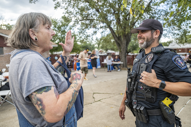 Tabitha Bergman visits with Georgetown Police officer Ivan Macias  at the National Night Out observance held at the Georgetown Housing Authority’s Stonehaven site  on Tuesday, October 7, 2025.  Photo by Andy Sharp.