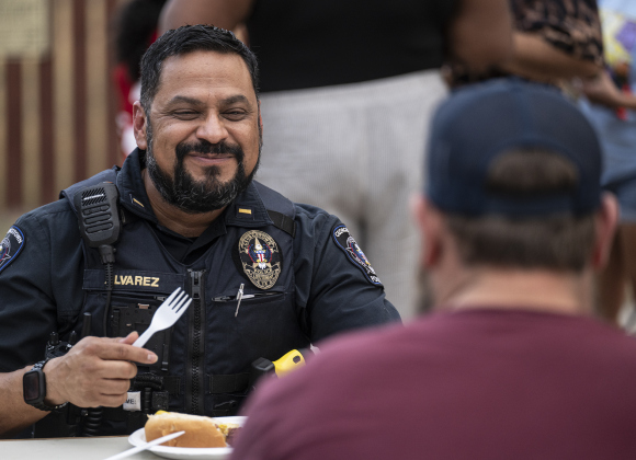 Georgetown Police Lt. Rene Alvarez visits with Blake Brennan  at the National Night Out observance held at the Georgetown Housing Authority’s Stonehaven site  on Tuesday, October 7, 2025.  Photo by Andy Sharp.