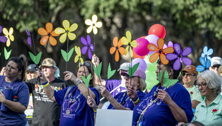 Participants prepare to take part in the Walk to End Alzheimer’s, held at Southwestern University on  Saturday morning, October 18, 2025.  The flowers they’re holding include purples, representing someone who has lost someone to Alzheimer’s, blue, meaning someone living with the disease, yellow, signifying someone who supports or cares for someone with Alzheimer’s,  and orange, meaning a person supports the cause.   The event was coordinated by the Alzheimer’s Association Capital of Texas Chapter.