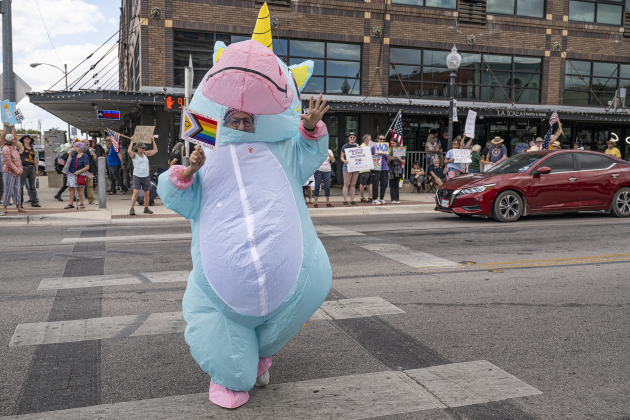 Sara Konovalski of Georgetown, dressed as a unicorn, crosses Main Street during a “No Kings” demonstration in downtown Taylor on on Saturday afternoon,  October 18, 2025. The crowd was approximately 300, mostly gathered at 2nd and Main Streets.  Photo by Andy Sharp.