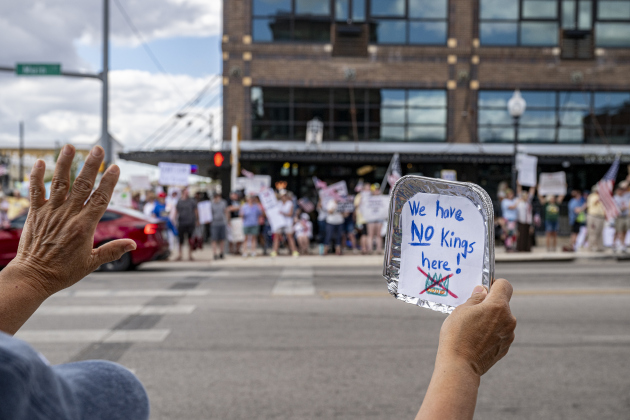 Mia Perez holds her small sign and waves from her spot at 2nd and Main Street during  a “No Kings” demonstration in downtown Taylor on on Saturday afternoon,  October 18, 2025. The crowd was approximately 300, mostly gathered at 2nd and Main Streets.  Photo by Andy Sharp.