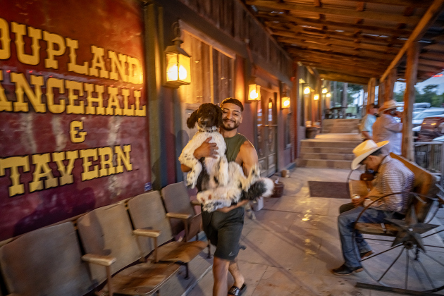 Jason Morano carries his dog named Po past the Coupland Dance Hall on Saturday, August 30, 2025.      Photo by Andy Sharp.