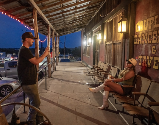Bo Rankin takes photos of Suzie Metzger on the front porch of  the Coupland Dance Hall on Saturday, August 30, 2025.     Photo by Andy Sharp.