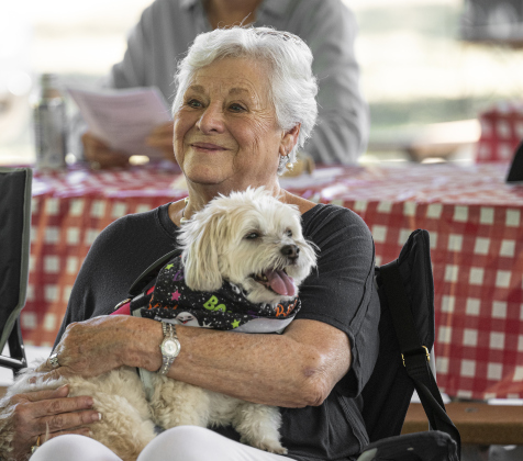 Jeanne Hollerich cuddles with Bernie during  a Blessing of the Animals service conducted by Grace Episcopal Church, held at Booty’s Road Park on Sunday, October 5, 2025. Hollerich is caring for Bernie while his owners, Ted and Lauri Berryman, are traveling out of the country, but Hollerich added “I love dogs!”   Lunch was provided at the park’s pavilion after the service acknowledging the work of Saint Francis of Assisi.   Photo by Andy Sharp.
