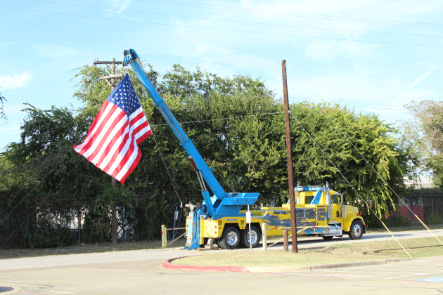 A tow truck from ASAP Towing in Florence hoists an American Flag for National Night Out.