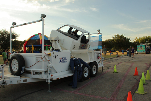 The TxDOT rollover simulator demonstrates the importance of wearing a seat belt as one dummy is ejected from the vehicle while another remains safely strapped in.