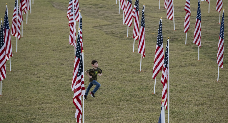 5-year-old Colton Ronchetto dashes through a field of American flags at the Georgetown Field of Honor in San Gabriel Park  on Saturday evening, November 8, 2025.