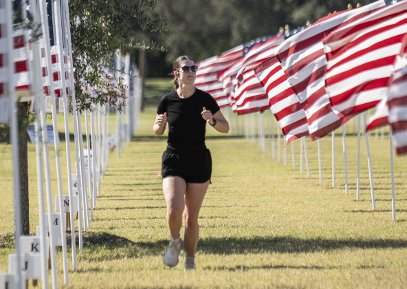 Caroline Baer, 3 (in white top) and her sister Kate, 1, enjoyed running under some of the 2000 American flags at the Georgetown Field of Honor on Sunday, November 9, 2025.