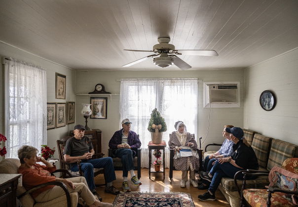 Friends gather in the living room of an original farmhouse  during Heritage Farm Day, held at the 125-year-old Lutonsky Farm on Saturday, November 15, 2025.  The lady in the bonnet is Georgia Ann Kelley, a member of the Lutonsky family.  The farm is located on County Road 405, south of Taylor.