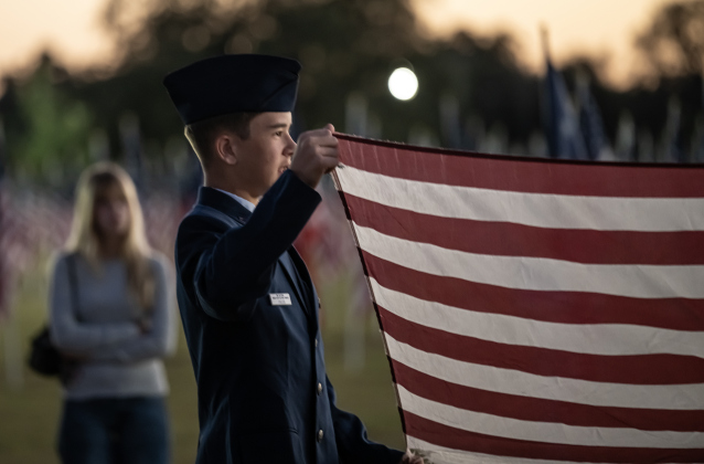 14-year-old Trigg Fuller, a Civil Air Patrol member, prepares a flag for retirement during a flag retirement ceremony at the Field of Honor on Friday, November 14, 2025.  Taking part in the ceremony were members of Scouting America Troop 1096, representatives from the Civil Air Patrol, veterans and active duty military, plus members of the public.  Photo by Andy Sharp.