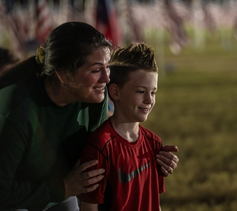 Kadie Tidwell and her son Bear, 8, attended a flag retirement ceremony at the Field of Honor on Friday, November 14, 2025.  Taking part in the ceremony were members of Scouting America Troop 1096, representatives from the Civil Air Patrol, veterans and active duty military, plus members of the public.  Photo by Andy Sharp.